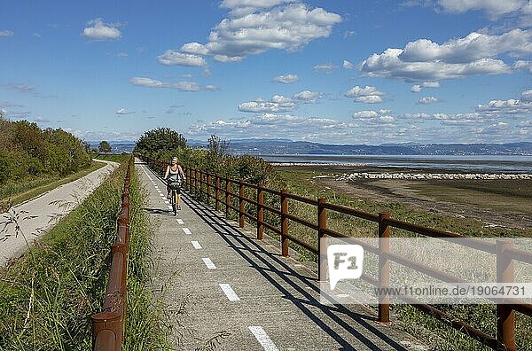 Radfahrerin am Radweg entlang der Küste von Grado nach Punta Sdobba  Grado  Friaul-Julisch Venetien  Italien  Europa