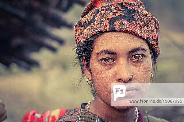 Dolpo  Nepal  ca. Mai 2012: Einheimische Frau mit Piercing und Ohrringen trägt ein orangefarbenes Kopftuch mit braunen Augen in Dolpo  Nepal. Dokumentarischer Leitartikel  Asien