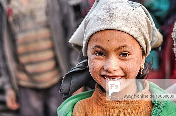 Dolpo  Nepal  ca. Mai 2012: Ein junges Mädchen mit braunen Augen und Ohrringen trägt ein weißes Kopftuch und ein gelbes Sweatshirt in Dolpo  Nepal. Dokumentarischer Leitartikel  Asien