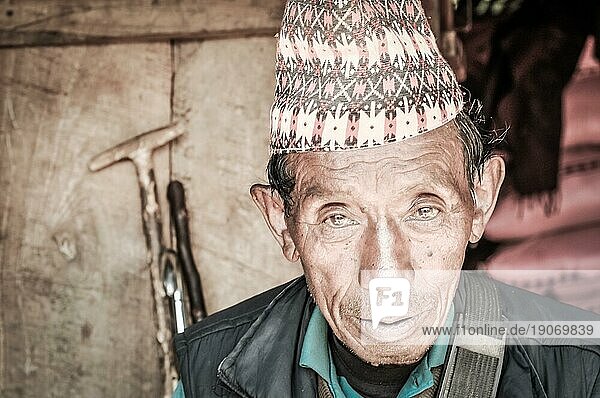 Beni  Nepal  ca. Mai 2012: Alter einheimischer Mann mit braunen Augen und bunter Mütze auf dem Kopf auf der Straße in Beni  Nepal. Dokumentarischer Leitartikel  Asien