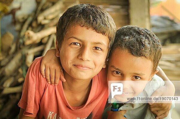 Damak  Nepal  etwa im Mai 2012: Zwei junge Brüder mit braunen Augen umarmen sich und lächeln in die Fotokamera im nepalesischen Flüchtlingslager in Damak  Nepal. Dokumentarischer Leitartikel  Asien