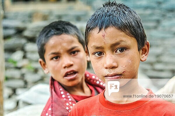 Beni  Nepal  ca. Mai 2012: Zwei junge braunhaarige Jungen in roter Kleidung mit großen braunen Augen schauen neugierig in die Fotokamera in Beni  Nepal. Dokumentarischer Leitartikel  Asien