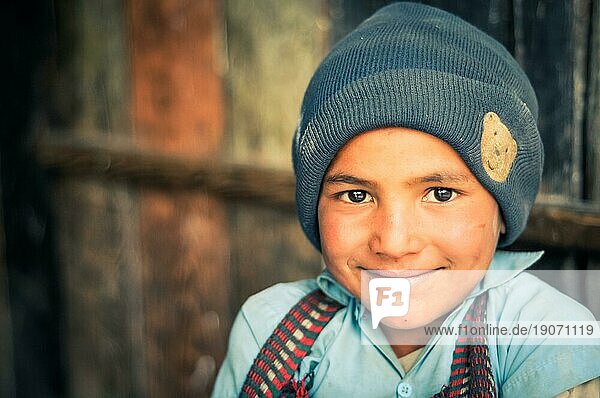 Beni  Nepal  ca. Mai 2012: Foto eines jungen einheimischen Jungen mit großen braunen Augen  der eine graue Mütze und ein blaues Hemd trägt und freundlich in die Kamera lächelt  in Beni  Nepal. Dokumentarischer Leitartikel  Asien