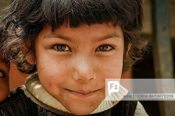 Beni  Nepal  ca. Mai 2012: Junges Mädchen mit kurzen braunen Haaren und schönen braunen Augen hat Schmutz auf den Wangen und schaut schüchtern in die Fotokamera in den Straßen von Beni  Nepal. Dokumentarischer Leitartikel  Asien