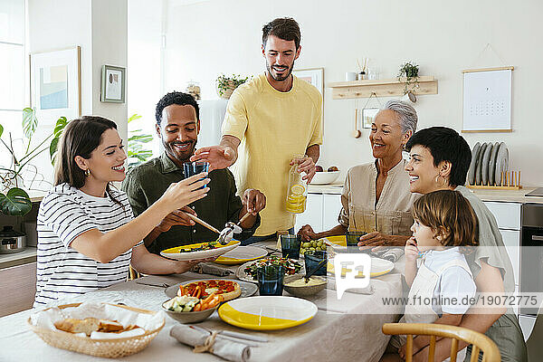 Happy family spending leisure time having lunch in kitchen