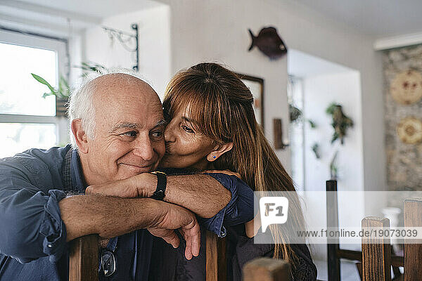 Happy woman kissing man in coffee shop