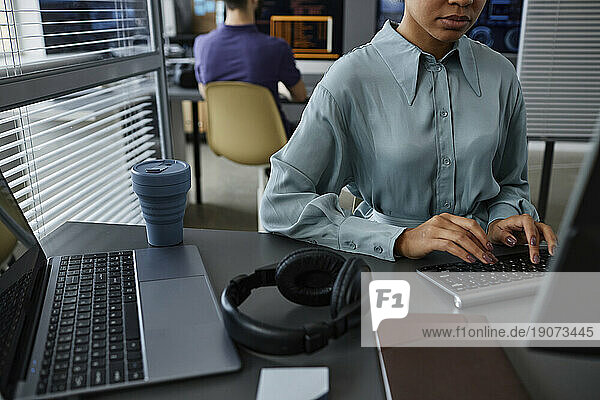 IT professional typing on keyboard with colleague in background