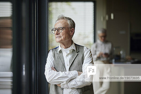 Senior man at home looking out of window
