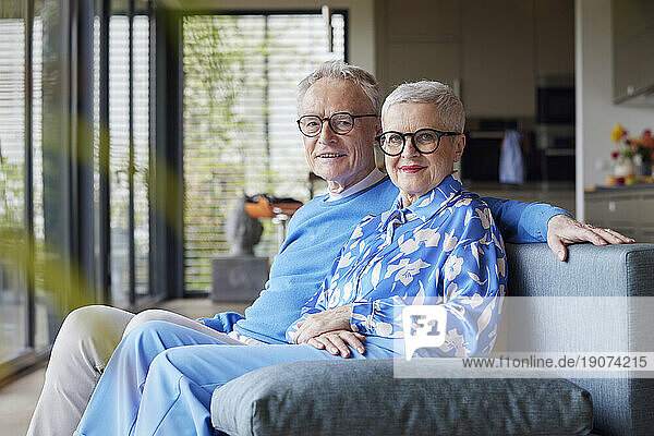 Portrait of senior couple sitting on couch at home