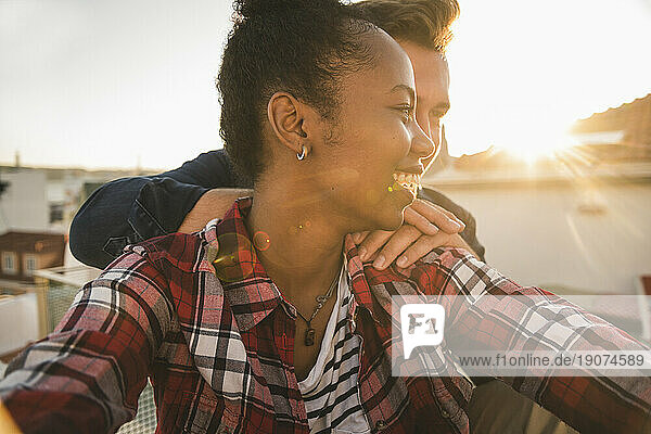 Happy affectionate young couple on rooftop in the evening
