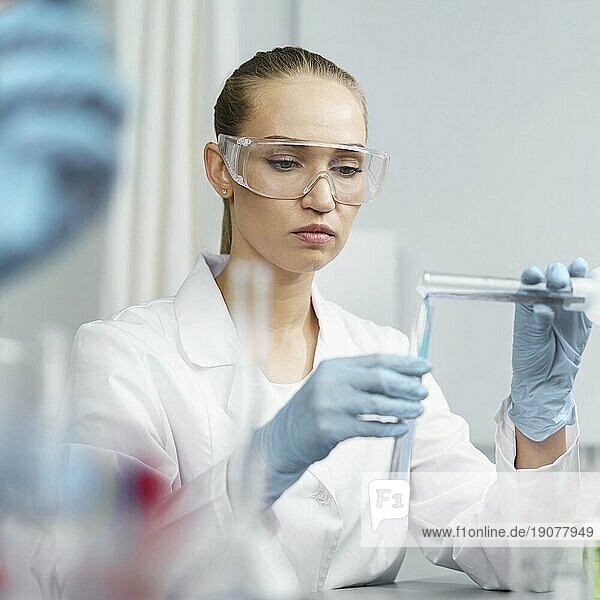 Frontansicht weibliche Forscherin Labor mit Reagenzgläsern Schutzbrille