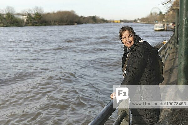 Lächelnde reife Frau posiert mit Blick in die Kamera in einem Fluss