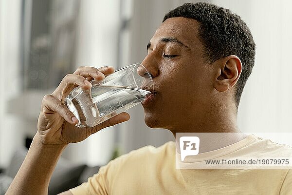 Porträt Mann zu Hause trinkt Glas Wasser