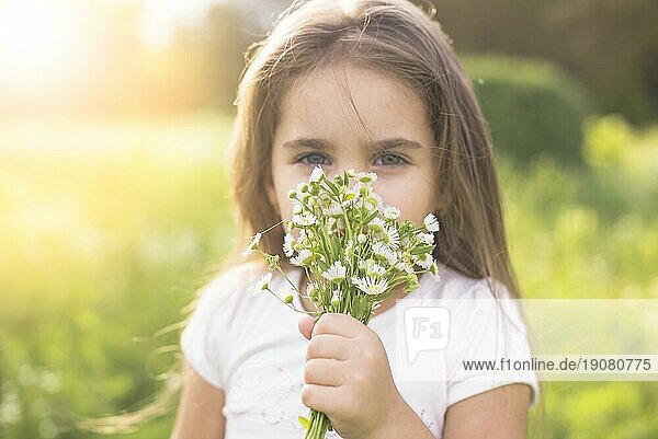 Mädchen riecht an weißen Blumen
