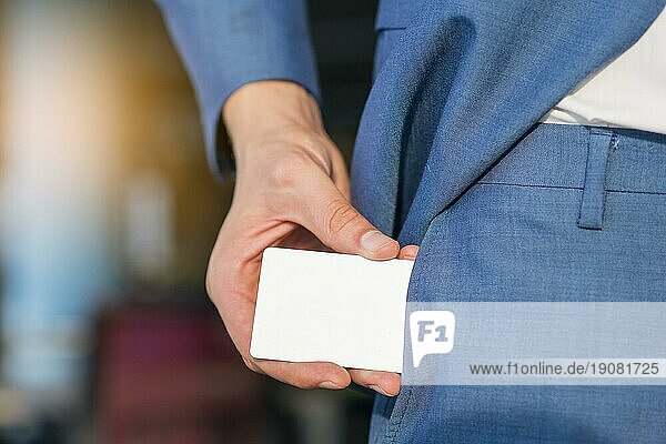 Geschäftsmann zieht eine leere weiße Karte aus seiner Tasche