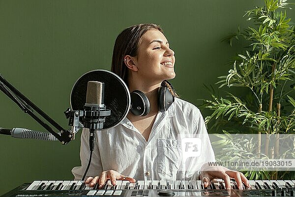 Frontansicht smiley weiblichen Musiker spielen Klavier Tastatur drinnen