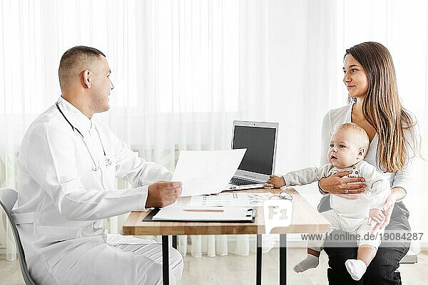 Seitenansicht Arzt im Gespräch mit Mutter und Kind