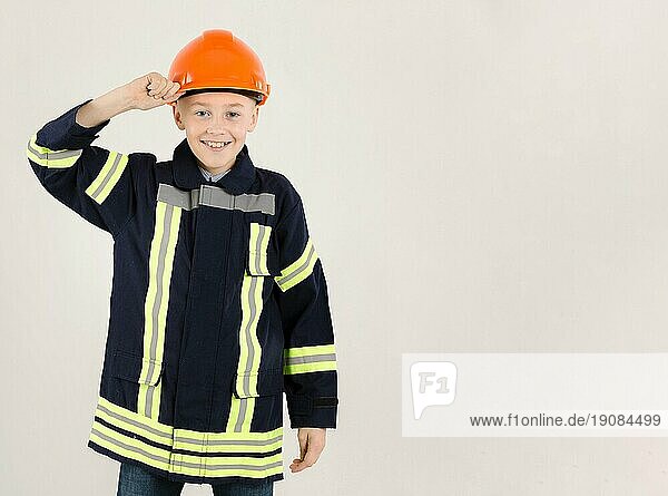 Liebenswerter junger Feuerwehrmann kopiert Raum