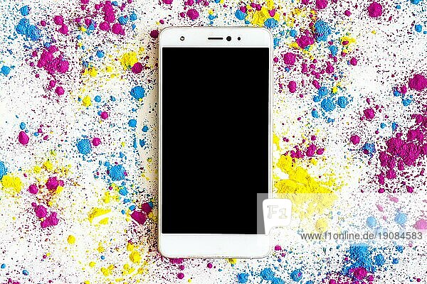 Holi Farbpulver um Smartphone mit schwarzem Bildschirm