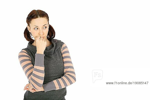 Junge lässige Frau in nachdenklicher Pose  die nach rechts schaut  vor weißem Hintergrund
