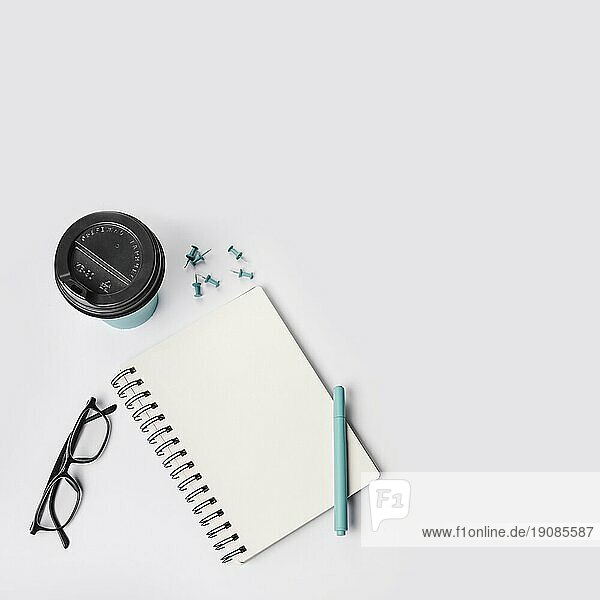 Overhead Ansicht Einweg Kaffeebecher Push Pins Stift Brillen Spirale Notizblock weißem Hintergrund