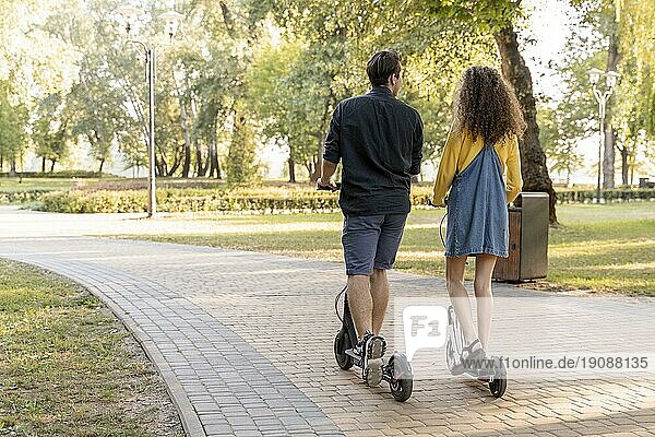 Nettes junges Paar fährt Roller im Freien