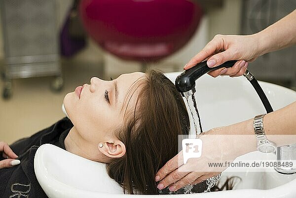 Blondes Mädchen wäscht sich die Haare