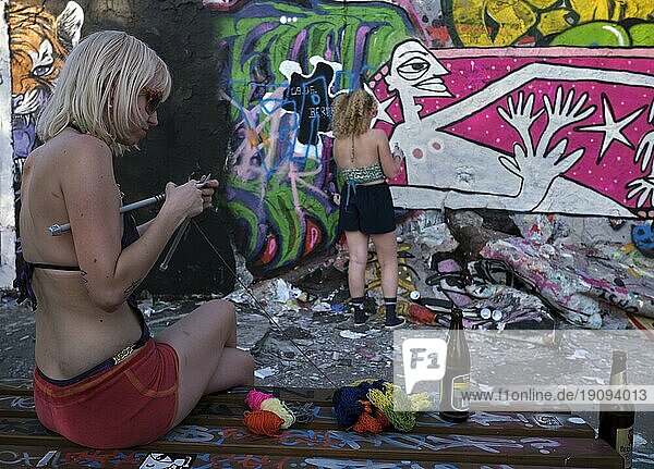 Deutschland  Berlin  11.06.2023  Sonntagnachmittag im Mauerpark  Strickende und sprayende Holländerinnen an der Graffitimauer  Europa