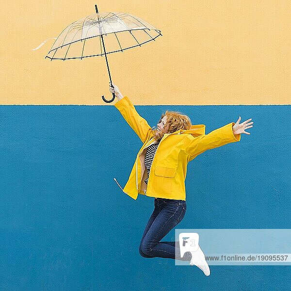 Mädchen springt Regenschirm