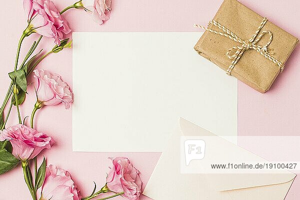 Blankopapier mit Umschlag frische rosa Blume braun eingewickelt Geschenkbox rosa Hintergrund