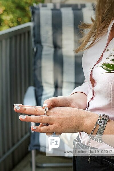 Hand einer jungen Frau mit einem schönen Ring. Verlobung. Die Szene auf dem Balkon. Vertikales Bild