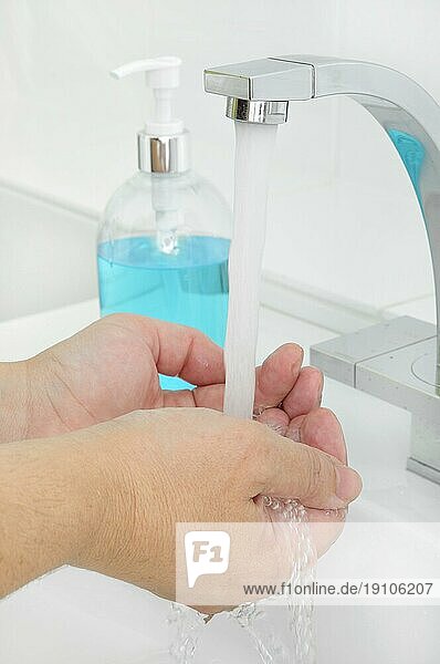 Hände unter laufenden Wasser waschen