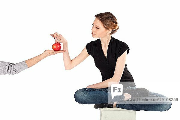 Schlanke Frau auf Diät  die einen roten Apfel aus der Hand eines Mannes nimmt  isoliert vor weißem Hintergrund