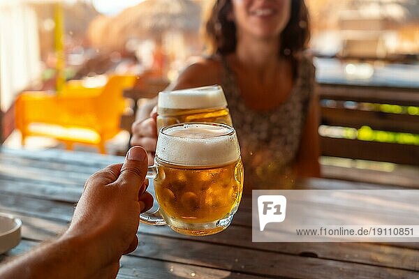 Trinkspruch auf ein Paar  das im Sommer am Strand ein paar Bier trinkt  um die Freundschaft zu feiern