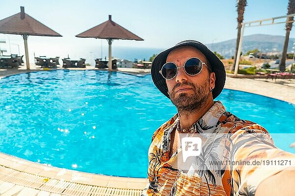 Tourist Mann im Hotelpool im Sommer ein Selfie genießen den Urlaub nehmen