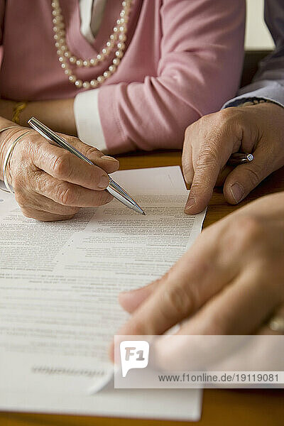 Close up of man and woman hands signing documents