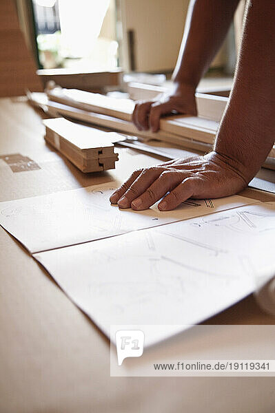Close up of man's hands on flat pack furniture instructions