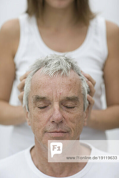 Close up of gray haired man receiving head massage