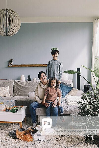 Porträt einer glücklichen Familie beim Müllsammeln im heimischen Wohnzimmer