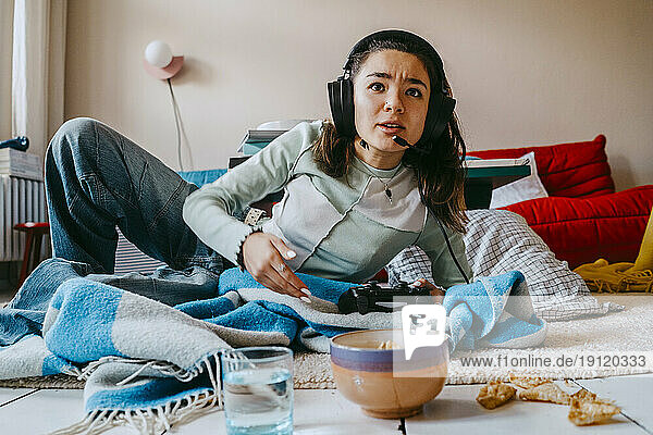 Woman playing video game in living room at home