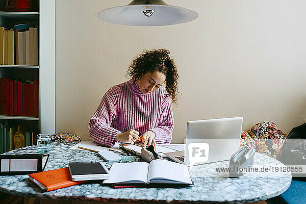 Junge Frau macht Hausaufgaben am Tisch