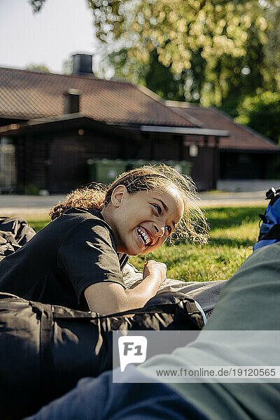 Seitenansicht eines glücklichen Mädchens  das lachend im Sommercamp liegt