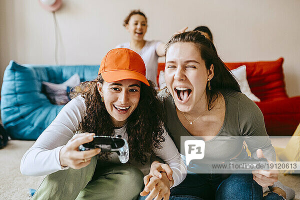 Verspielte junge Freundinnen spielen ein Videospiel zu Hause