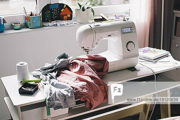 Nähmaschine mit Kleidung auf dem Tisch