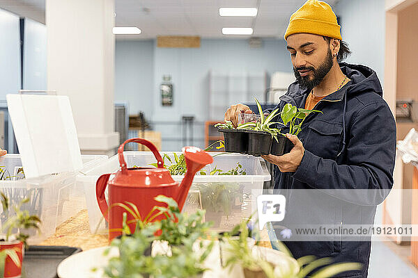 Männlicher Kunde mit Jacke beim Kauf von Pflanzen im Recyclingzentrum