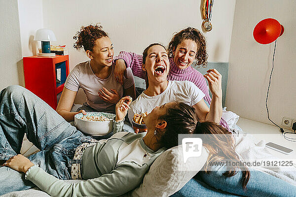 Weibliche Freunde haben Spaß und genießen Snacks zu Hause