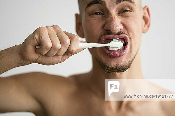Vorderansicht Mann beim Zähneputzen morgens