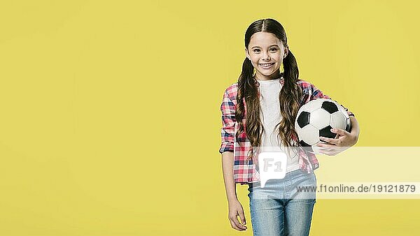 Mädchen posiert mit Fußballstudio