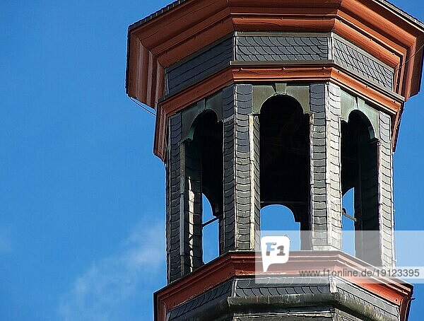 Altertümlicher Glockenturm einer Kirche in Saarbrücken  Ausschnitt  Hintergrund blaür Himmel