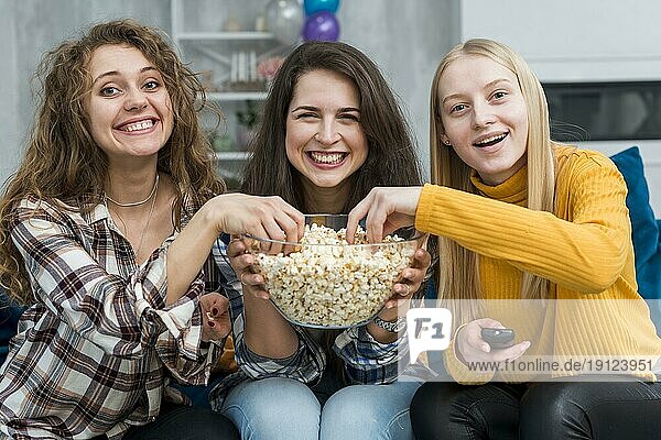 Freunde schauen einen Film und essen Popcorn